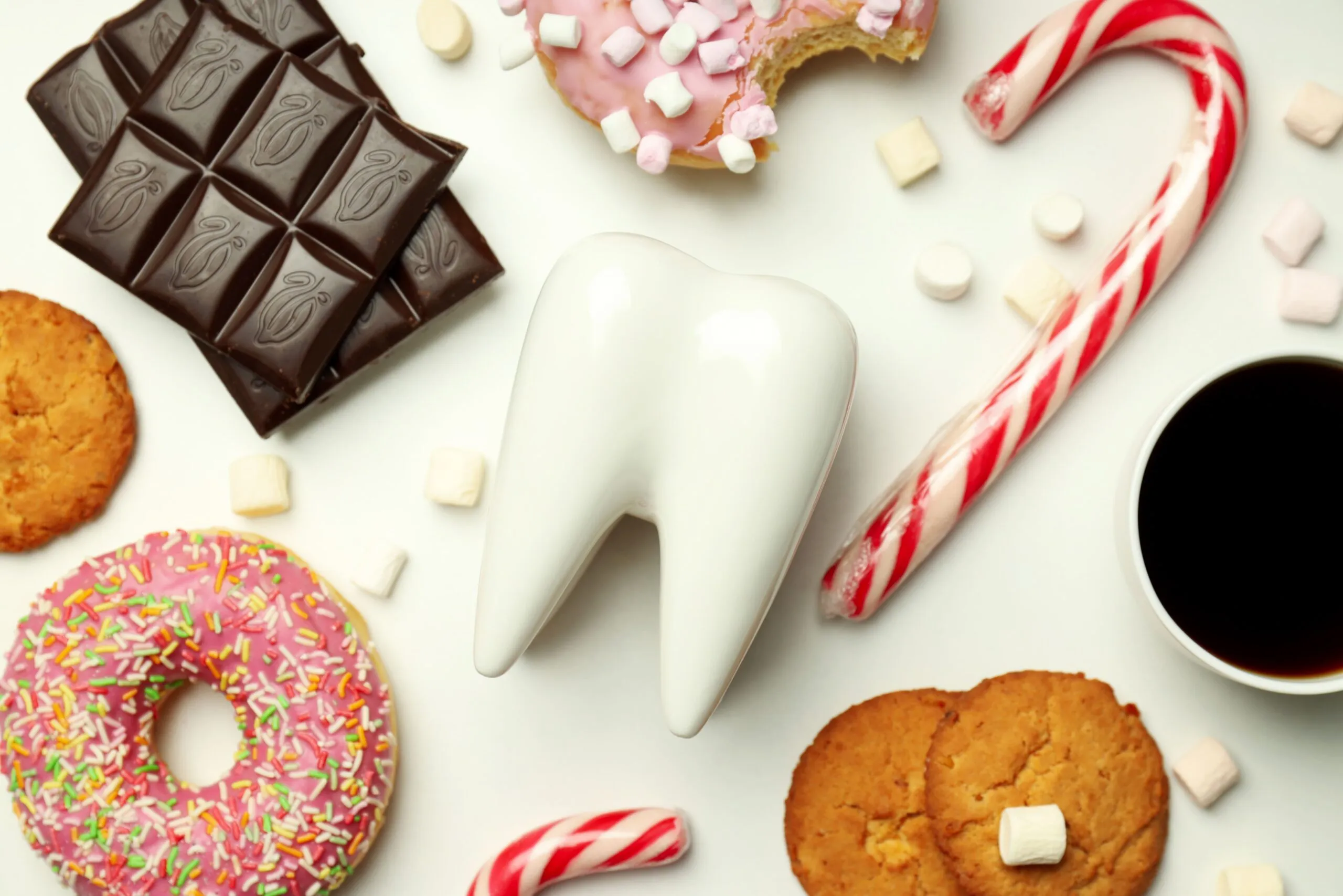 A tooth surrounded by candy and other sweets